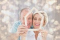 Composite image of happy older couple holding house shape Royalty Free Stock Photo