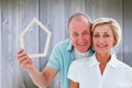 Composite image of happy older couple holding house shape Royalty Free Stock Photo