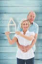 Composite image of happy older couple holding house shape Royalty Free Stock Photo