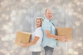 Composite image of happy older couple holding moving boxes Royalty Free Stock Photo