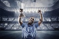 Composite image of happy sportsman looking up and cheering while holding trophy Royalty Free Stock Photo