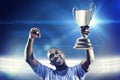 Composite image of happy sportsman looking up and cheering while holding trophy Royalty Free Stock Photo