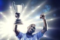 Composite image of happy sportsman looking up and cheering while holding trophy Royalty Free Stock Photo