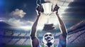 Composite image of happy sportsman looking up while holding trophy Royalty Free Stock Photo