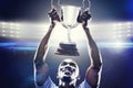 Composite image of happy sportsman looking up while holding trophy Royalty Free Stock Photo