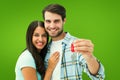 Composite image of happy young couple holding new house key Royalty Free Stock Photo