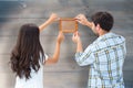 Composite image of happy young couple putting up picture frame Royalty Free Stock Photo