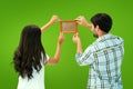 Composite image of happy young couple putting up picture frame Royalty Free Stock Photo