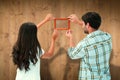 Composite image of happy young couple putting up picture frame Royalty Free Stock Photo