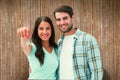 Composite image of happy young couple showing new house key Royalty Free Stock Photo