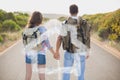 Composite image of hiking couple standing on countryside road