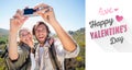 Composite image of hiking couple standing on mountain terrain taking a selfie