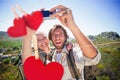 Composite image of hiking couple standing on mountain terrain taking a selfie