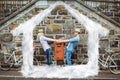 Composite image of hip young couple dancing by brick wall with their bikes