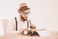 Composite image of hipster holding smoking pipe while working on Royalty Free Stock Photo