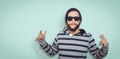 Composite image of hipster showing rock and roll hand sign Royalty Free Stock Photo