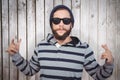 Composite image of hipster showing rock and roll hand sign Royalty Free Stock Photo