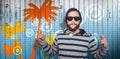 Composite image of hipster showing rock and roll hand sign Royalty Free Stock Photo