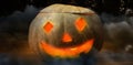 Composite image of illuminated jack o lantern on wooden table