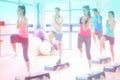 Composite image of instructor with fitness class performing step aerobics exercise Royalty Free Stock Photo