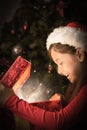 Composite image of little girl opening a magical christmas gift Royalty Free Stock Photo