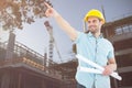Composite image of male architect with blueprints pointing away Royalty Free Stock Photo