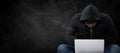 Composite image of male hacker using laptop while sitting Royalty Free Stock Photo