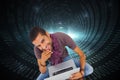 Composite image of man sitting on floor using laptop and smiling at camera Royalty Free Stock Photo