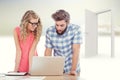 Composite image of man using laptop while discussing with woman at desk Royalty Free Stock Photo