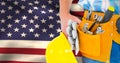 Composite image of manual worker wearing tool belt while holding gloves and helmet Royalty Free Stock Photo