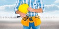 Composite image of manual worker wearing tool belt while holding hammer and helmet Royalty Free Stock Photo