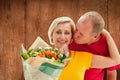 Composite image of mature man kissing his partner holding flowers Royalty Free Stock Photo