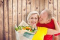 Composite image of mature man kissing his partner holding flowers Royalty Free Stock Photo