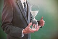 Composite image of mid section of businessman holding hourglass Royalty Free Stock Photo