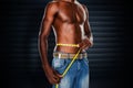 Composite image of mid section of a fit shirtless man measuring waist