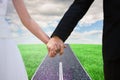 Composite image of mid section of newlywed couple holding hands in park Royalty Free Stock Photo