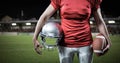 Composite image of mid section of sportsman holding american football and helmet Royalty Free Stock Photo