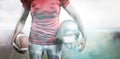 Composite image of mid section of sportsman holding american football and helmet Royalty Free Stock Photo