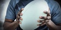 Composite image of mid section of sportsman holding rugby ball