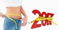 Composite image of mid section of a woman measuring waist in a big sized jeans Royalty Free Stock Photo