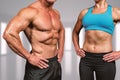 Composite image of midsection of muscular man and woman with hands on hip