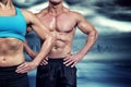 Composite image of midsection of muscular woman and man standing with hands on hip