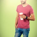 Composite image of midsection of smiling model holding disposable coffee cup Royalty Free Stock Photo
