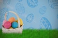 Composite image of mulit colored easter eggs in wicker basket