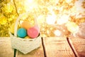 Composite image of mulit colored easter eggs in wicker basket