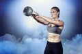 Composite image of muscular woman swinging heavy kettlebell Royalty Free Stock Photo