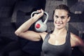 Composite image of muscular woman swinging heavy kettlebell Royalty Free Stock Photo