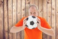 Composite image of nervous football fan holding ball