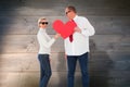 Composite image of older affectionate couple holding red heart shape Royalty Free Stock Photo