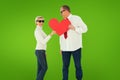 Composite image of older affectionate couple holding red heart shape Royalty Free Stock Photo